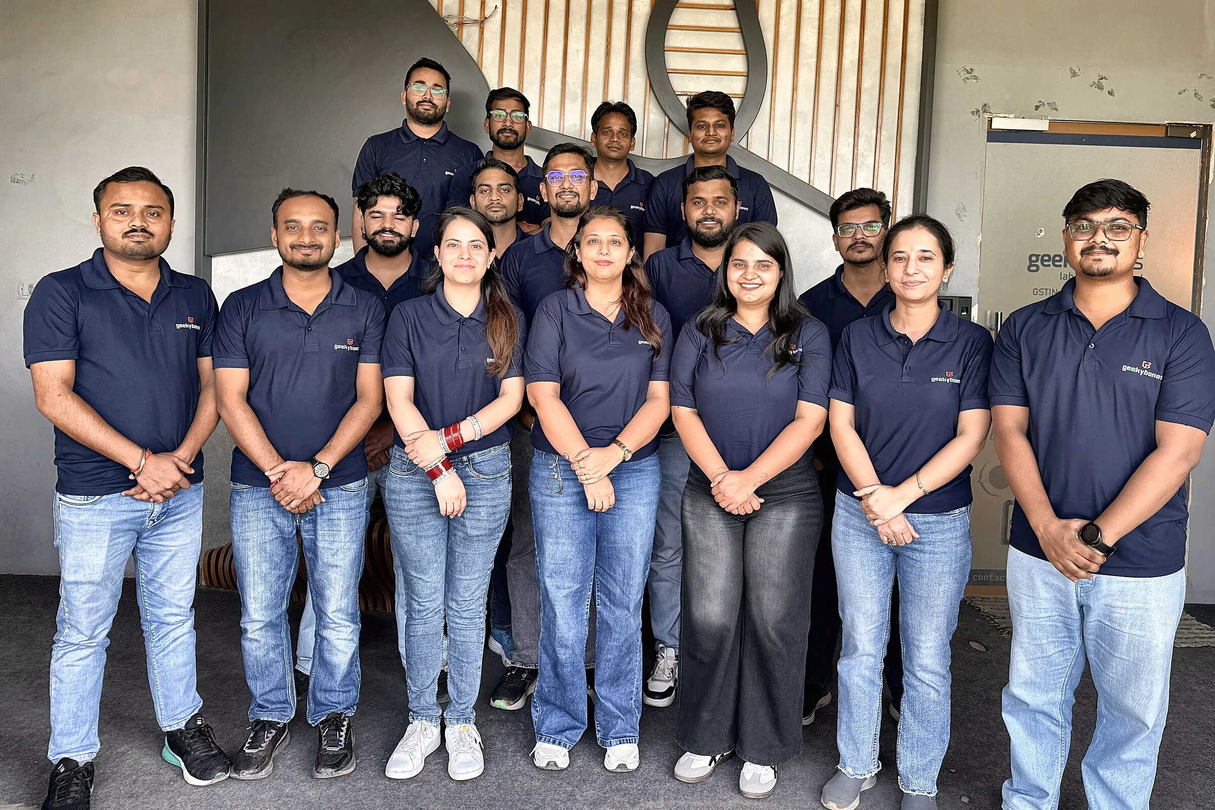 The GeekyBones team together outside the office, in matching branded polo shirts